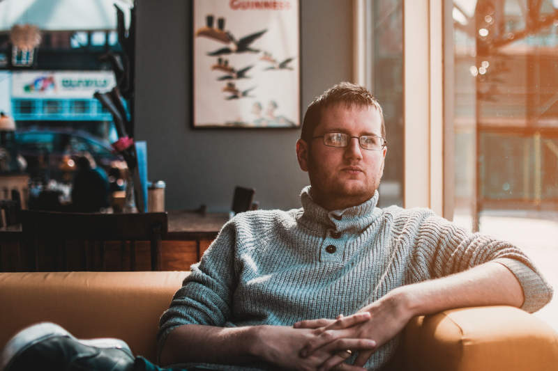 Lonely man on sofa staring out window